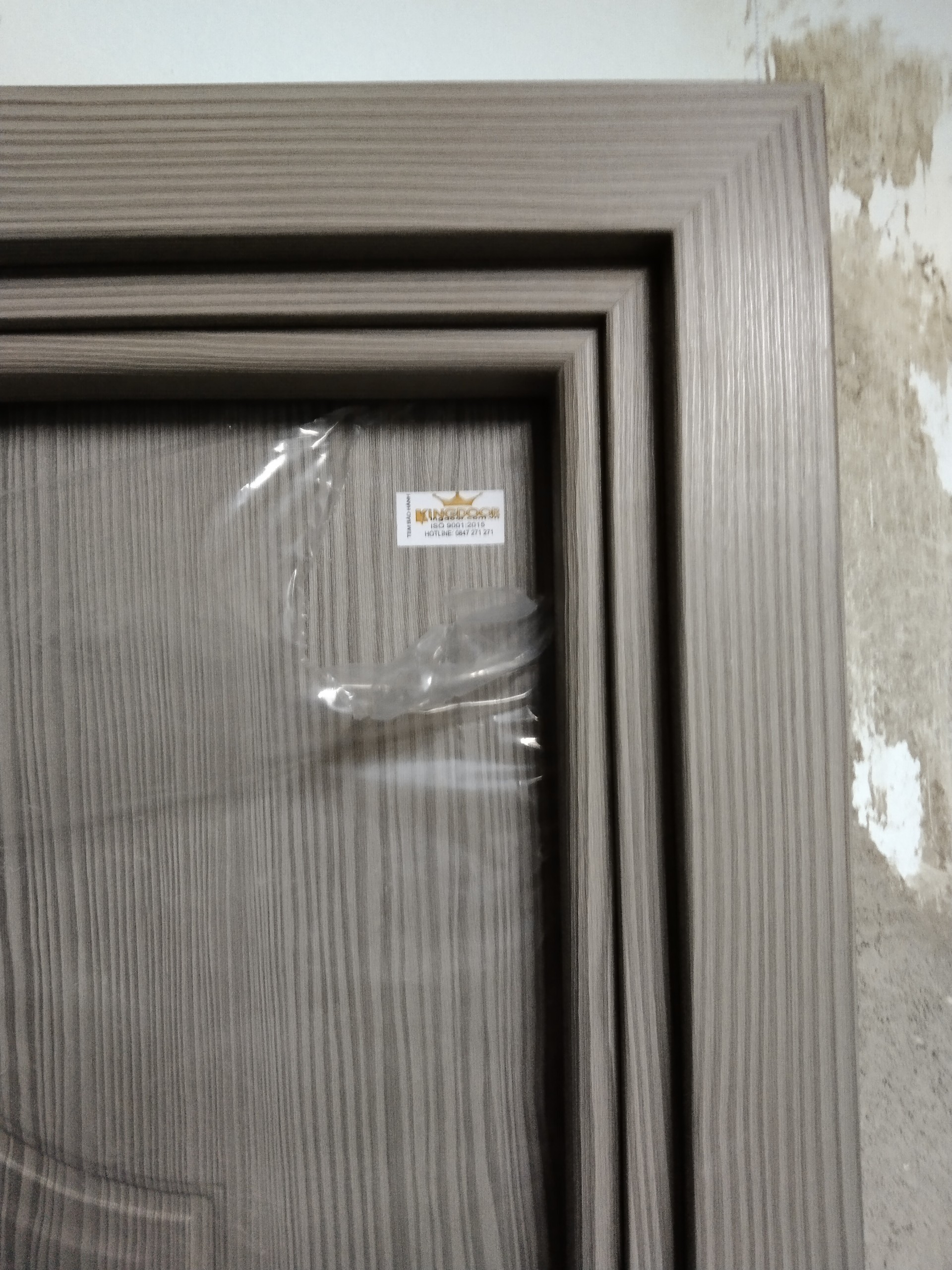 Cửa nhựa gỗ composite có tem bảo hành được gắn trên đầu cánh cửa