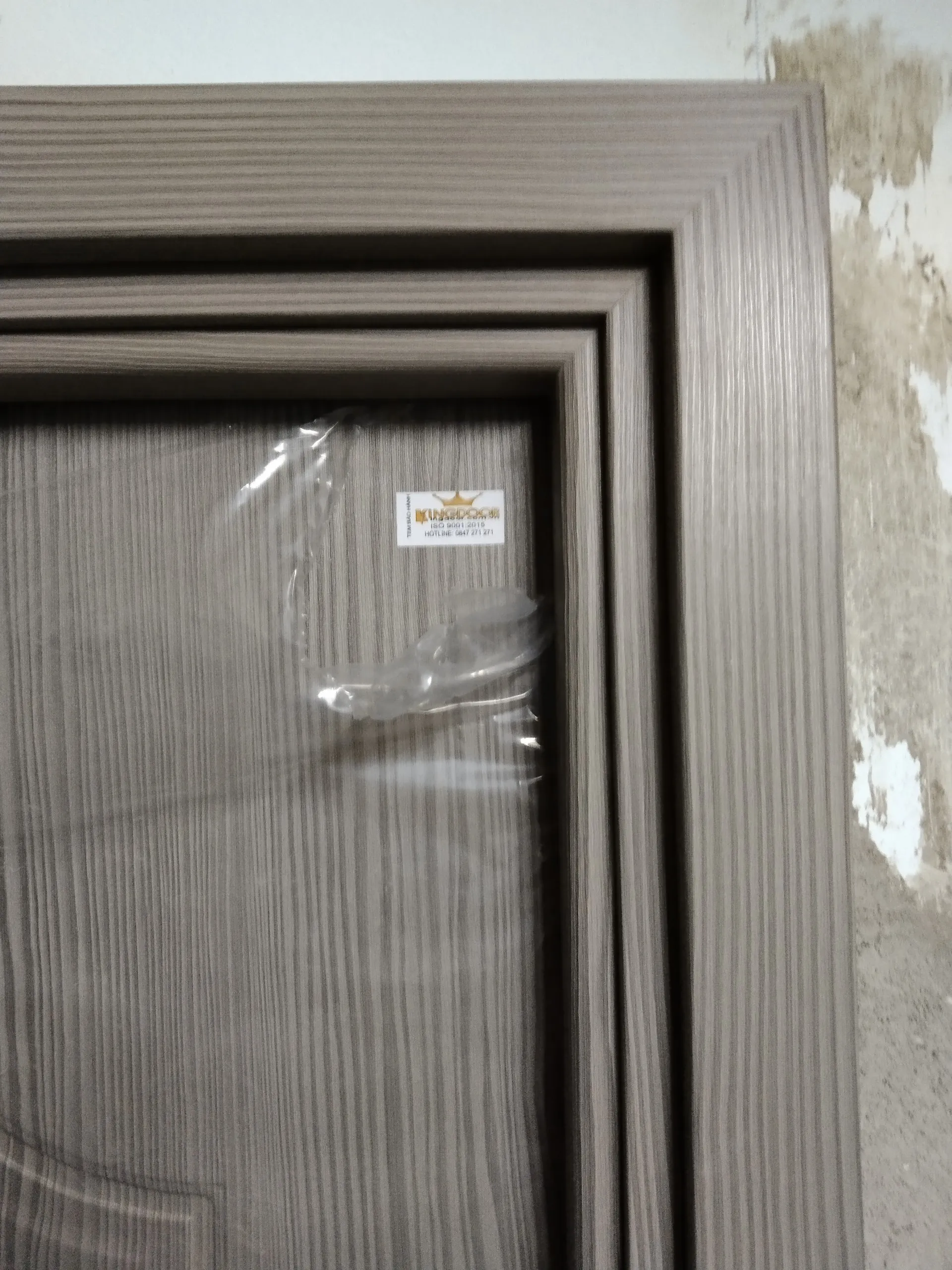 Cửa nhựa gỗ composite có tem bảo hành được gắn trên đầu cánh cửa
